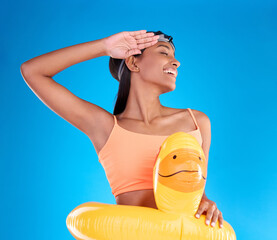 Sticker - Rubber duck, smile and salute with a swimmer woman in studio on blue background wearing goggles on her head. Happy, hand gesture and swimming with an attractive young female excited to swim in summer