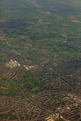 Canvas Print - Vertical aerial shot of green fields, buildings and roads during daytime from a plane