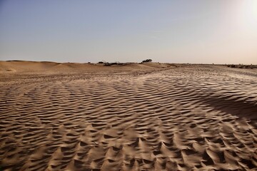 scenic view of desert against sky under the clear blue sky with the sun shining bright