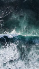 Wall Mural - Vertical aerial shot of the waves on a deep blue sea