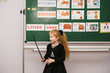 © Serhii - Pupil studies near blackboard. Cute schoolgirl reading sounds, letters in classroom at elementary school. Student doing test in primary. Flashcards for kindergarten, preschool children. English lesson