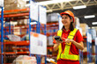 © NVB Stocker - Warehouse female staff worker wearing hardhat helmet working on barcode scanner handheld at warehouse factory