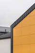 Kolorowa elewacja obiektu, budynku. Materiał z pionowych pomarańczowych paneli. 