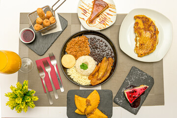 Wall Mural - Some typical dishes of Venezuelan food with a flag tray, cachapas, assorted desserts, corn empanadas and teques stuffed with cheese