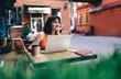 © BullRun - Female entrepreneur working on computer in cafe