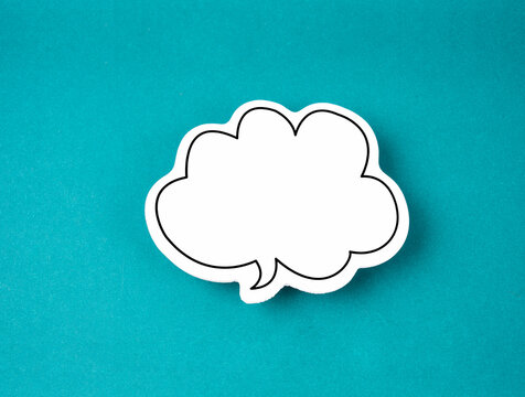 The White speech bubble shaped post it note on green background with copy space.