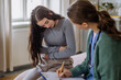 © Halfpoint - Teenage girl having stomach ache, young doctor examining her.