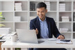 © David - Handsome young business asian man using digital laptop at Busy elegant bearded adult company director, checking the company finances, at the office.