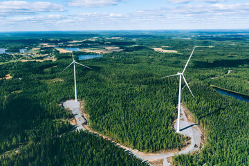 Wall Mural - Windmills, wind turbines. Aerial view of windmills in green summer forest in Finland.