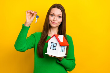 Sticker - Photo of friendly positive person arm hold small house showing key isolated on yellow color background