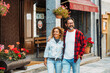 © simona - Happy adult young couple of tourist walking together in the street shops town and smiling looking around. Mountain and spring summer holiday vacation people. Love and relationship man and woman