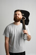 © Volodymyr - Handsome brunette bearded man musician standing and holding a acoustic guitar on a shoulder on a white background studio.