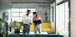 © Wavebreak Media - Diverse business people using laptop, holding documents and discussing, working late at office