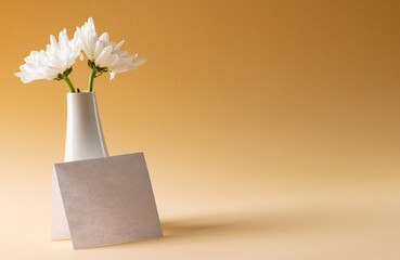 Wall Mural - Image of white flowers in white vase and card with copy space on yellow background