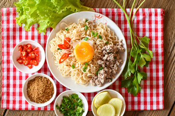 Wall Mural - instant noodles cooking tasty eating with bowl - noodle soup, noodles bowl with boiled egg minced pork vegetable spring onion lemon lime lettuce celery and chili on table food