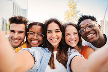 Group Of Happy Multiracial Teenagers Having Fun Smiling Taking A Selfie Portrait Together On A Students Meeting. Five Multiethnic Young Friends Laughing And Taking A Photo With A Smartphone. High