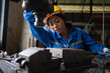 African black woman wearing blue safety uniform working control with heavy machine in factory