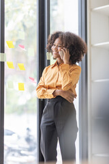 Wall Mural - Cheerful business Asian woman freelancer making telephone call share good news about project working in office workplace, african american business woman finance concept.