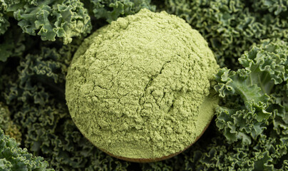 Wall Mural - A Bowl of Green Kale Powder on Bed of Kale Leaves