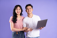 Image Of Asian Couple Using Laptop, Isolated On Purple Background