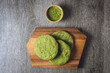 Matcha cookies with macadamia nuts and white chocolate chips on a dark wooden table