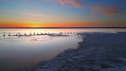 Wall Mural - Flying low toward sunrise over abstract and beautiful, surreal landscape of tranquil water and ice.
