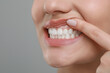 © New Africa - Woman showing healthy gums on grey background, closeup. Space for text