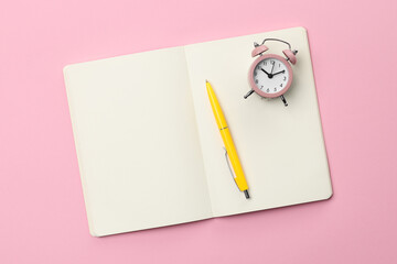 Canvas Print - Ballpoint pen, notebook and alarm clock on pink background, top view