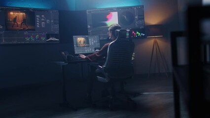 Fototapete - Female film editor or colorist does color grading on computer in modern studio. Big monitors with RGB colour correction graphic bar and program interface on the wall. Video post production. Handheld.