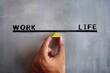 © izzuan - Hand holding wooden triangle with text WORK and LIFE. Work life balance concept