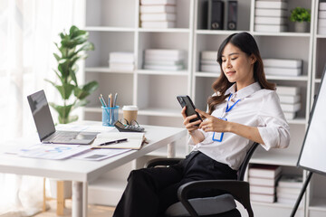 Wall Mural - Cheerful business Asian woman freelancer making telephone call share good news about project working in office workplace, employee business finance concept.