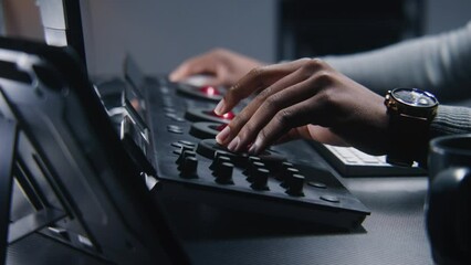 Fototapete - Hands close up of African American colorist working by color grading control panel in studio with modern design. Film editor makes colour correction for video post production. Professional equipment.
