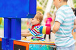 Children playing whack a mole arcade game at an amusement park