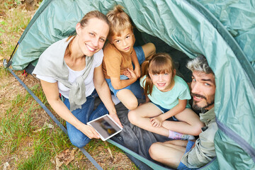 Wall Mural - Cheerful family camping together during vacation in forest