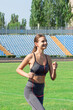 girl runs in the stadium and listening music to the player. Sports and healthy concept