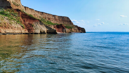 Wall Mural - View of the Black Sea and colorful clay cliffs with green grass near Koblevo. Ukraine. Europe	