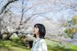桜の花を見るショートヘアの女性