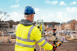 © Iryna - Surveyor builder site engineer with theodolite total station at construction site outdoors during surveying work