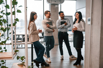 Four people standing in the office and working together