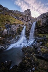  Vertical long exposure shot of the Klifbrekku Waterfall in Iceland