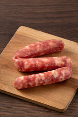 Wall Mural - Raw Taiwanese sausage in garlic flavor in a plate on wooden table background.