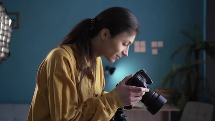 Wall Mural - Female photographer in an equipped home photo studio is preparing for the shooting. Studio light with softbox. Concept of the work process.