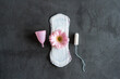 Menstruation period concept. Hygienic white female pad, Menstrual cup and tampon with pink flowers. Menstruation, protection. Women's health