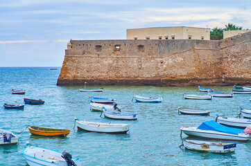 Wall Mural - Fishing boats at bastion of Santa Catalina Castle, Cadiz, Spain