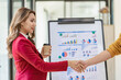 © ArLawKa - Businesswoman shaking hands and smiling while standing in modern office partner cooperation, colleague teamwork concept