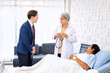 © Tongpool - Hospital treatment room relative visit patient lay on bed doctor explain update illness condition
