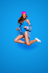 Poster - Vertical full size length body studio photo portrait of cheerful attractive pretty rejoicing confident funny fancy girl jumping up isolated bright color vivid shinny background