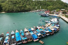 Blue And White Fishing Boat Anchored In A Harbor. Aerial Photography Of The Harbor. Indonesia Is A Maritime Country And The Largest Fish Producer In The World. Indonesian Harbour. Pantai Sadeng