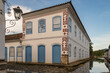 Paraty, Brazil. Old house from 1856 with Masonic symbols on the facade in the late afternoon. Stone street flooded by sea water. Water mirror reflecting the house with blue sky.