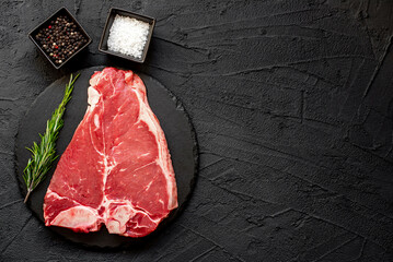 Wall Mural - raw T-bone steak on stone background with copy space for your text